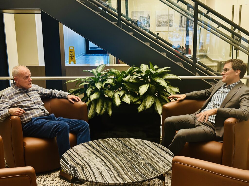 Steve Baker and Brad Barron sitting in a lobby having a conversation